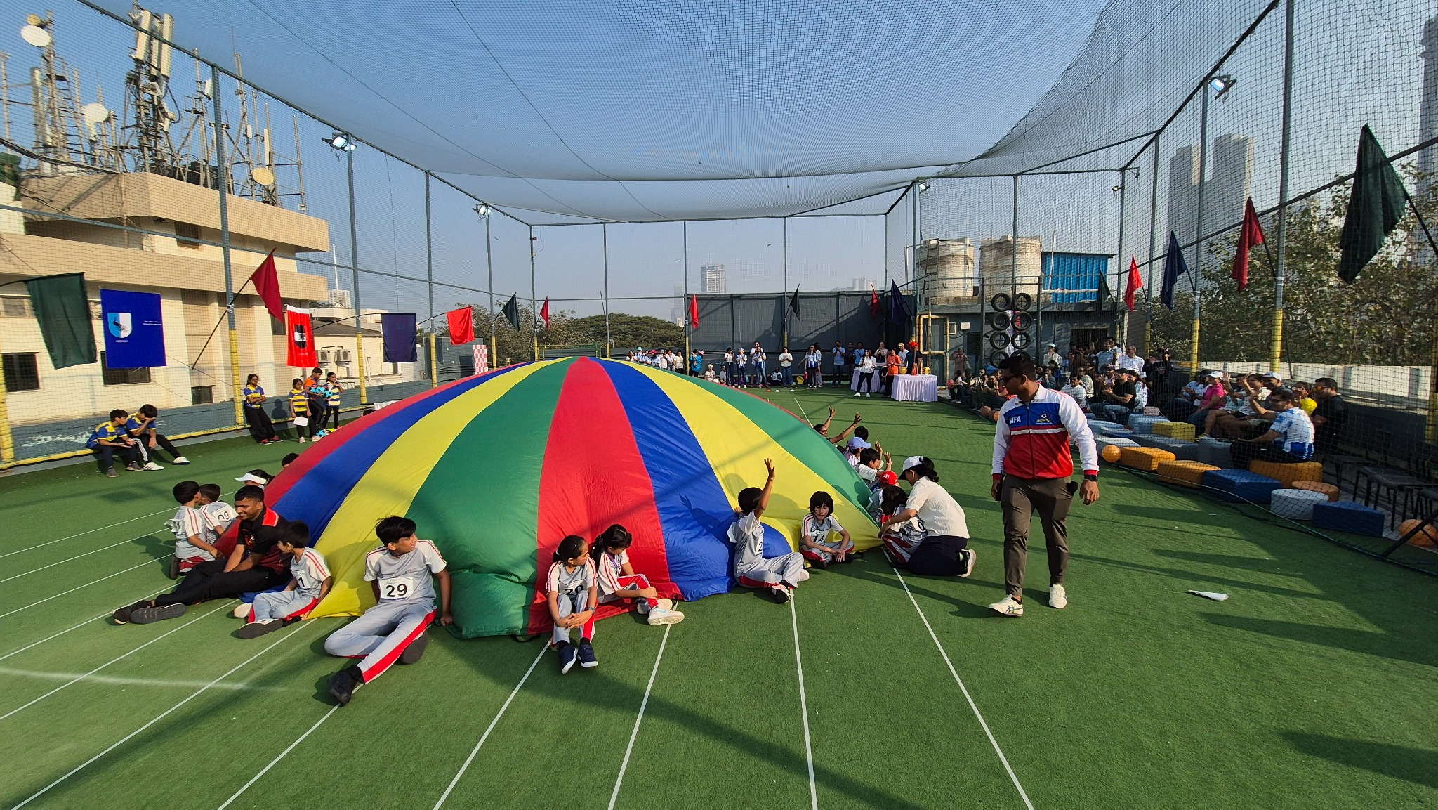 Children playing together around a colourful parachute at a sports event